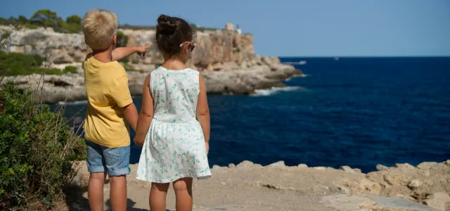 two children standing near cliff watching on ocean at daytime by Torsten Dederichs courtesy of Unsplash.